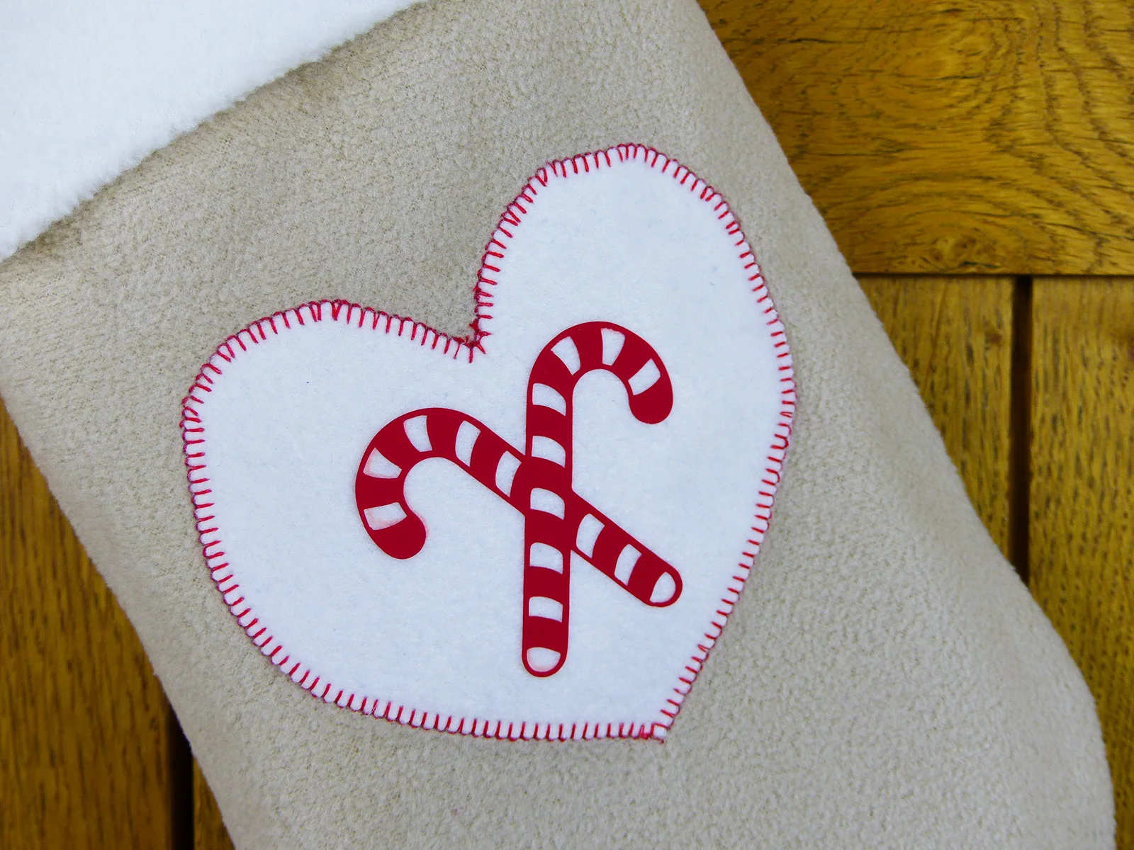 Zoom sur le cœur appliqué thermocollant sur la chaussette de Noël en polaire blanche