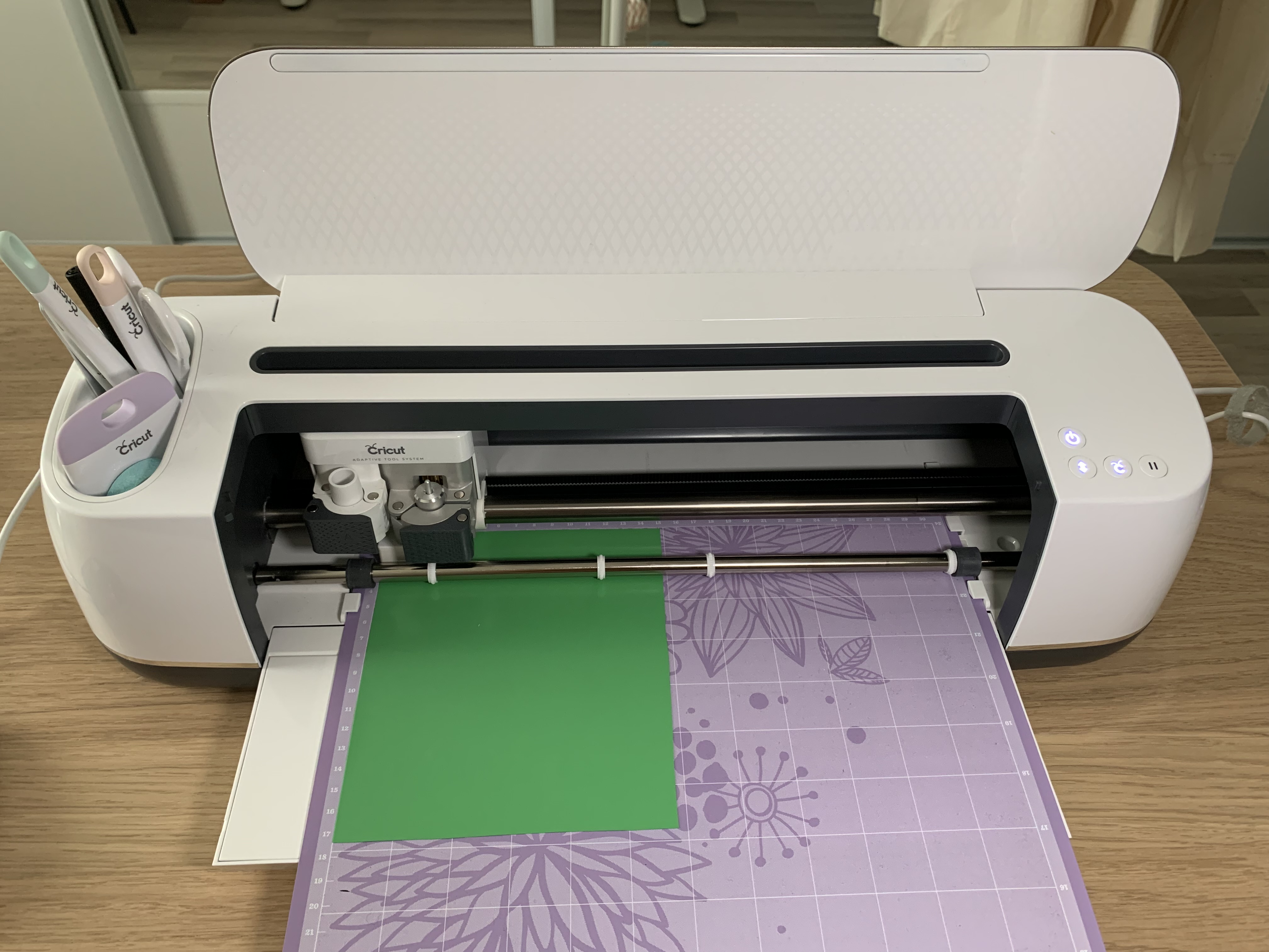 Cricut Maker en action découpant le flex thermocollant multicolore selon les calques du motif fleur