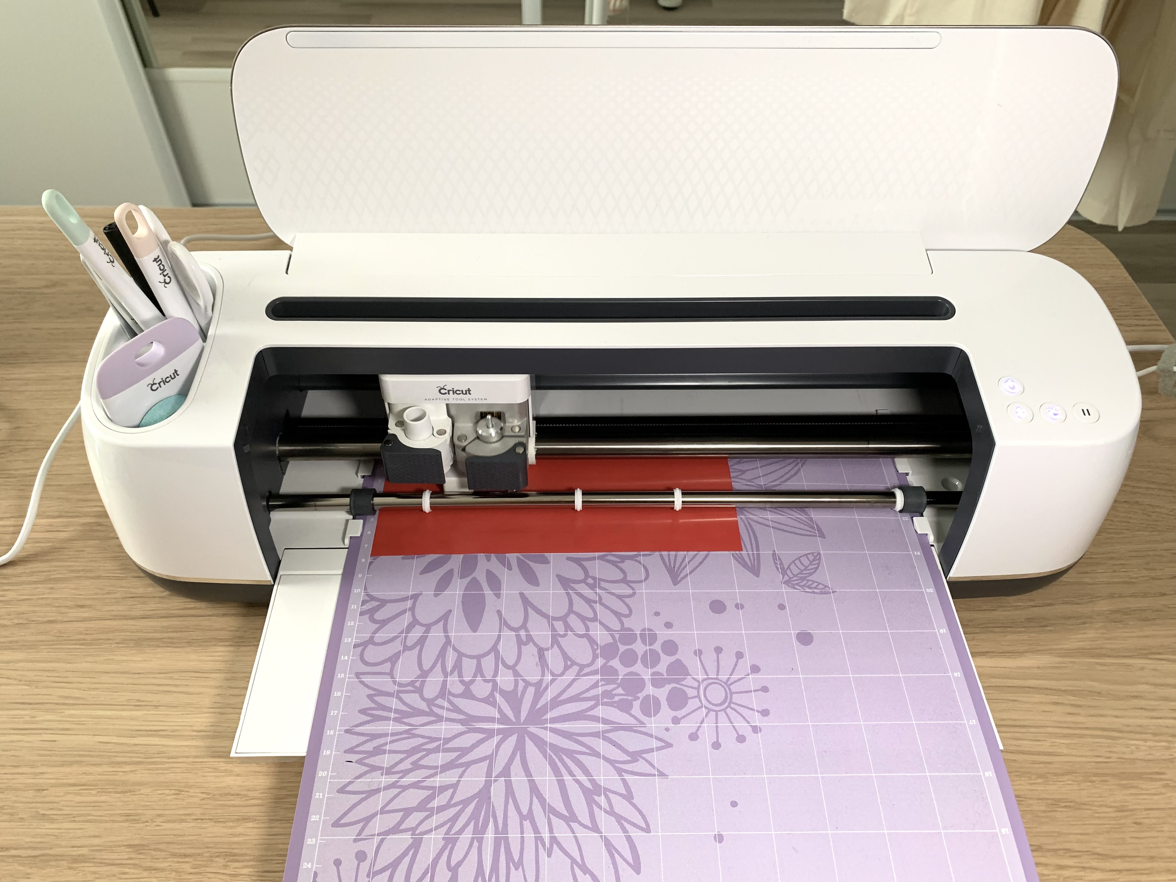 Cricut Maker en train de découper le flex thermocollant pour le motif dinosaure de Noël