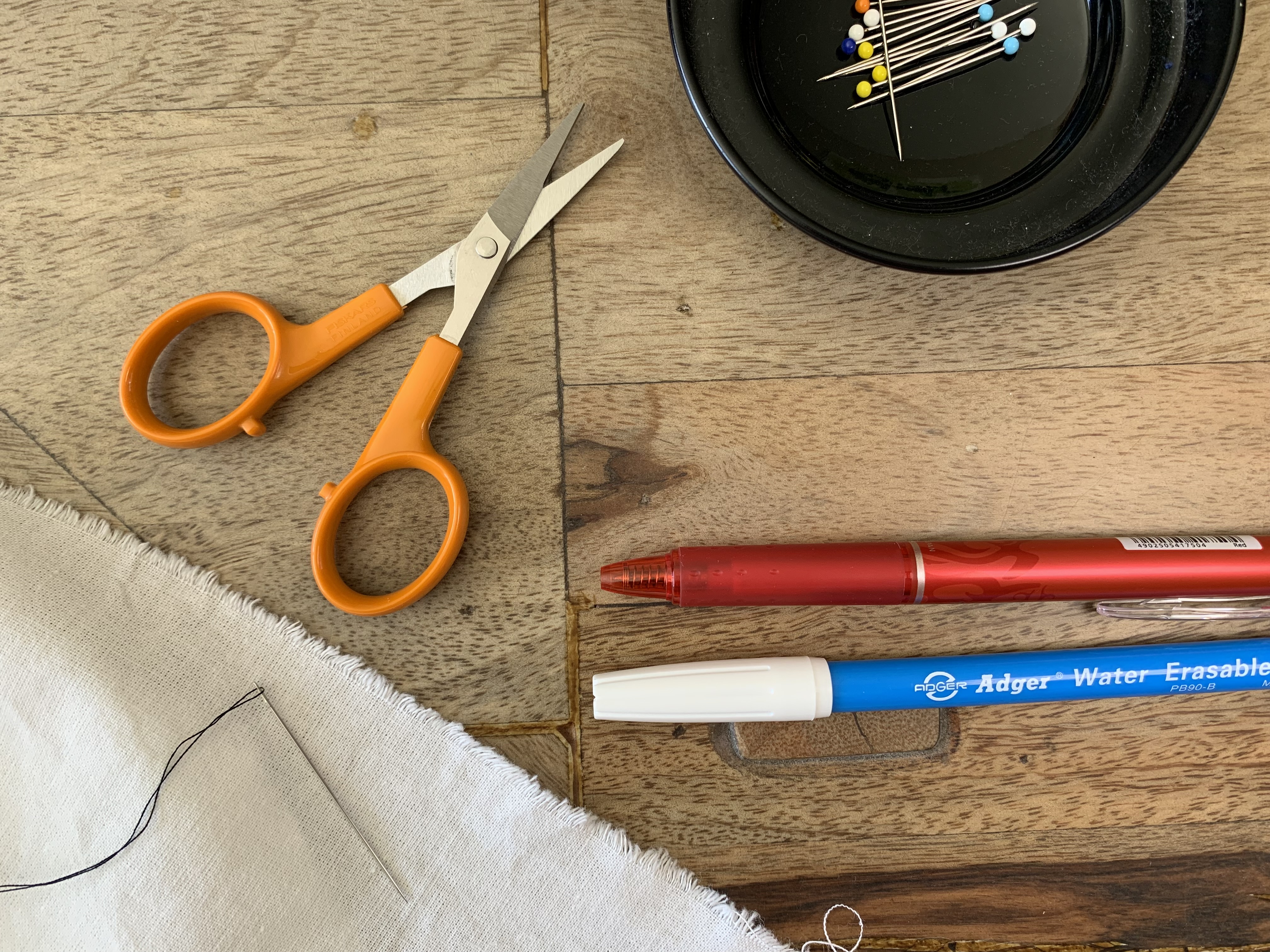 Collection d’outils pour marquer un patron de couture : craie, stylo, épingles, ciseaux