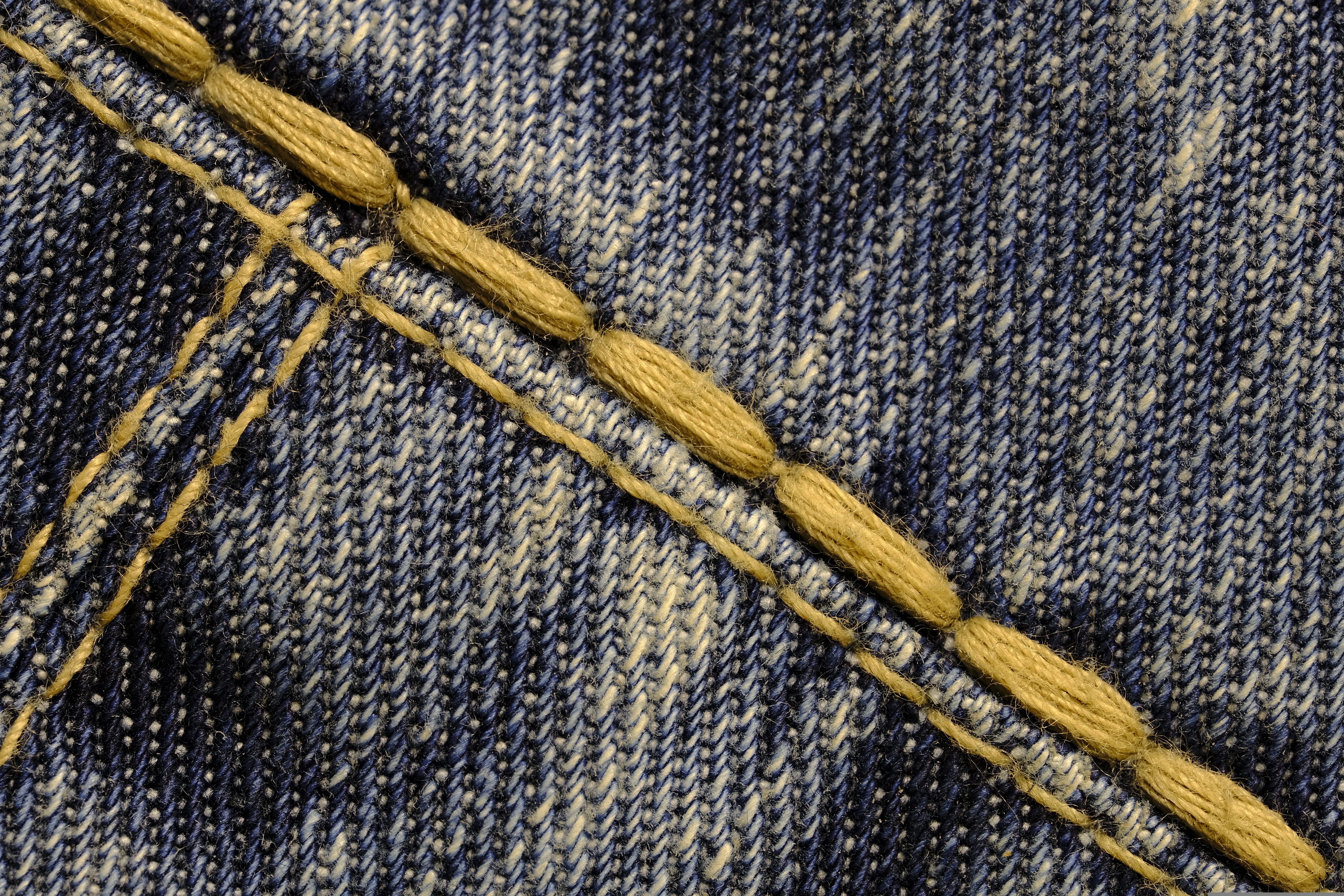 Points de renfort sur coutures denim aux zones sollicitées : entrejambe et poches jean