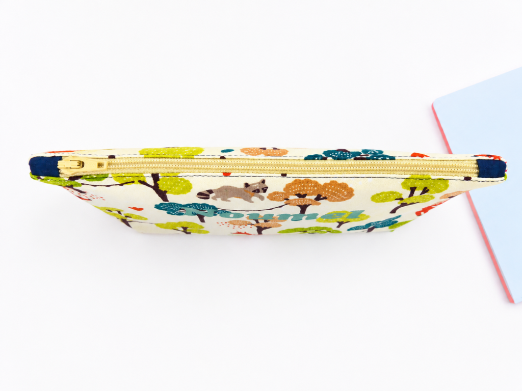 Trousse toupie en tissu imprimé animaux ouverte avec fermeture éclair bleue et doublure verte – patron de couture gratuit L’arbre à cousettes